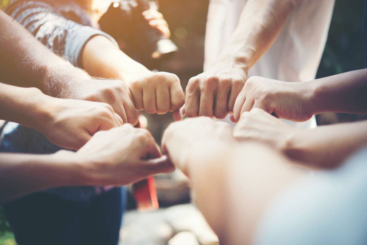 Close up of young people putting their hands together. Team with